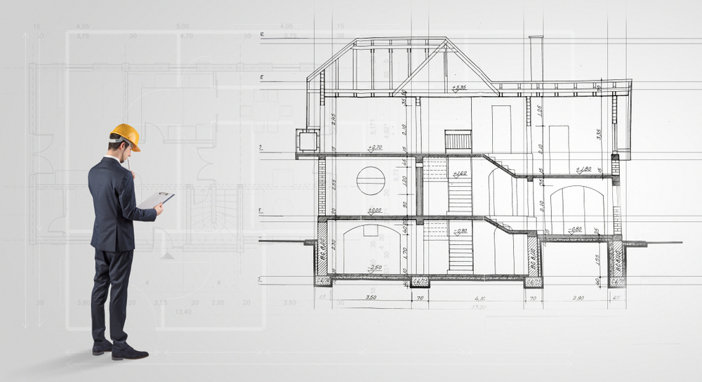 Architect watching a 2 dimension house plan Architect watching a 2 dimension house plan