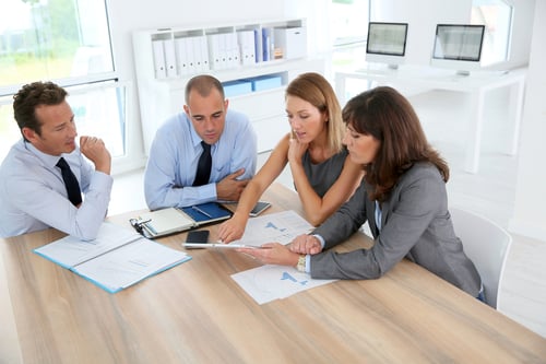 Group of business people meeting around table with tablet-1
