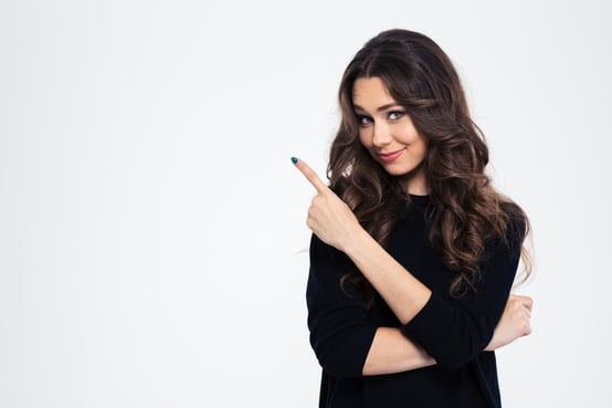 Portrait of a pretty girl pointing finger away isolated on a white background