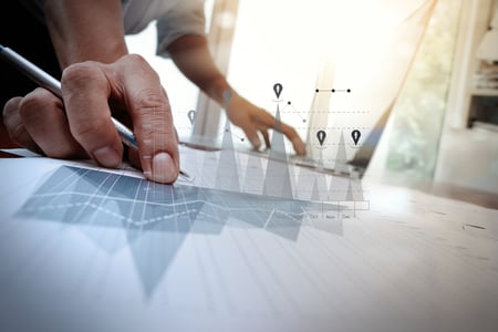 business documents on office table with smart phone and laptop computer and graph business with social network diagram and man working in the background