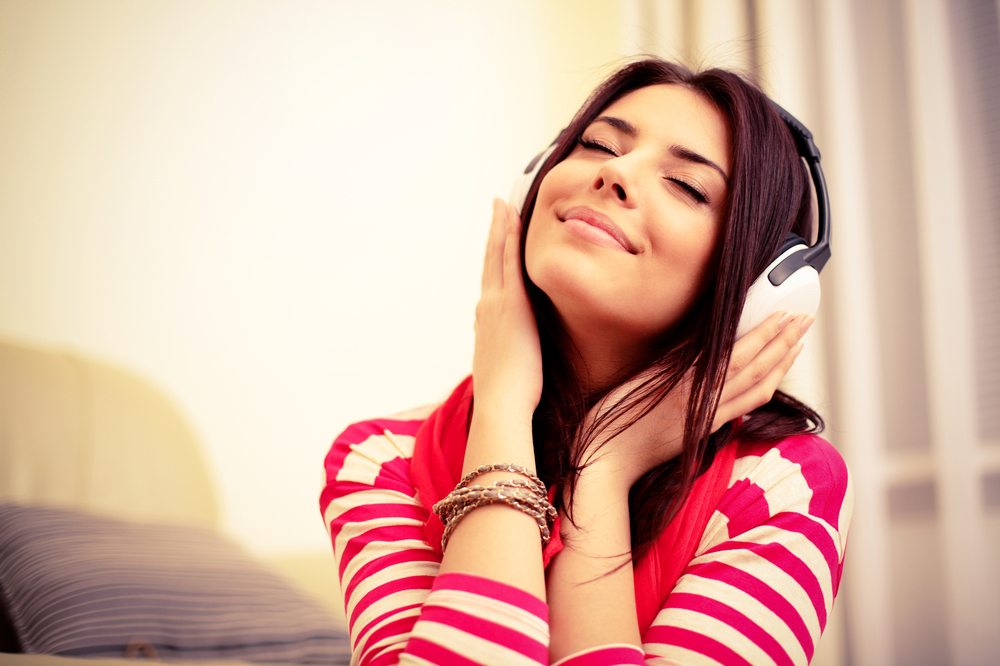 Young beautiful woman in bright outfit enjoying the music at home-1