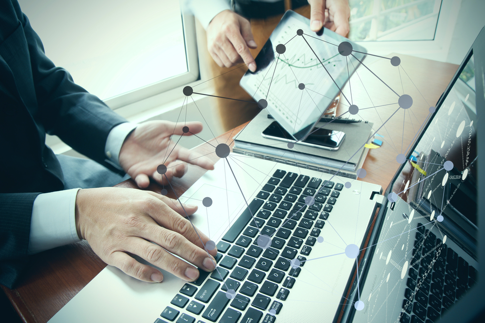 business documents on office table with smart phone and digital tablet and stylus and two colleagues discussing data in the background-2