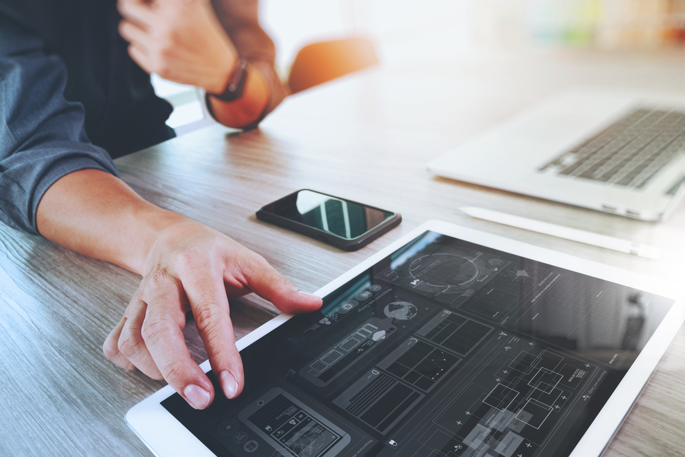 Website designer working digital tablet and computer laptop with smart phone and graphics design diagram on wooden desk as concept-3