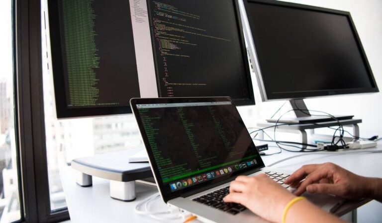 ノートパソコンでデータベース構築のコードを確認するエンジニアの手元
