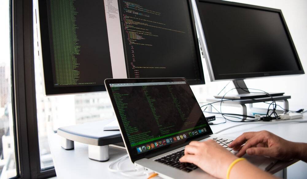 ノートパソコンでデータベース構築のコードを確認するエンジニアの手元